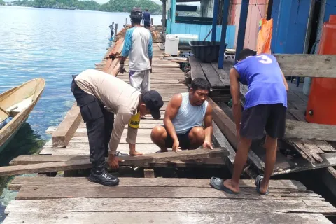 Bhabinkamtibmas Desa Mbokita Turun Tangan Bantu Warga Perbaiki Jalan Rusak
